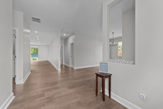 corridor featuring recessed lighting, visible vents, baseboards, and wood finished floors