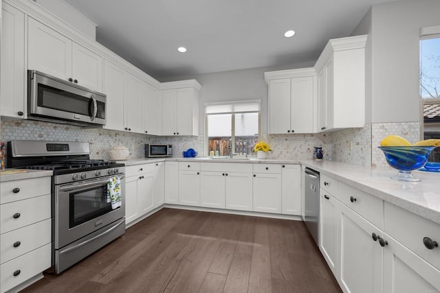 kitchen featuring appliances with stainless steel finishes, dark wood-style flooring, and white cabinets