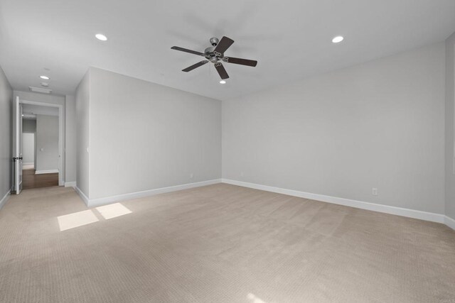 spare room featuring a ceiling fan, recessed lighting, light carpet, and baseboards