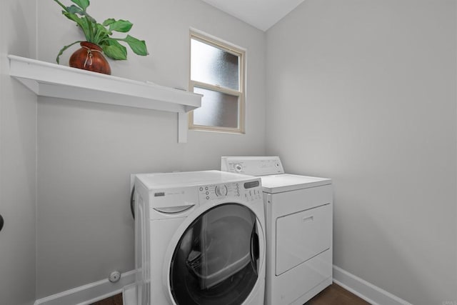 clothes washing area featuring laundry area, baseboards, and independent washer and dryer