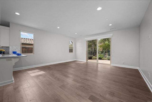 unfurnished living room featuring baseboards, wood finished floors, and recessed lighting