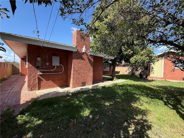 view of side of home featuring a yard and fence