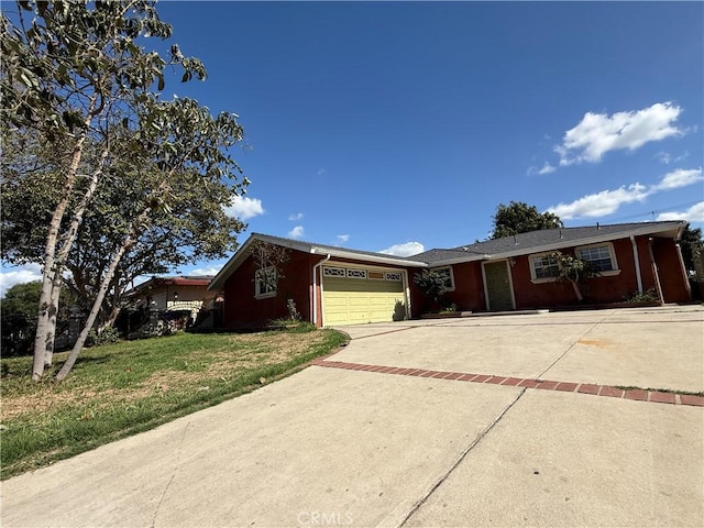 ranch-style home featuring a front yard, decorative driveway, and an attached garage