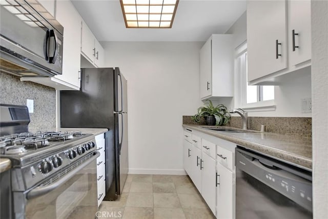 kitchen with light tile patterned floors, tasteful backsplash, white cabinets, black appliances, and a sink