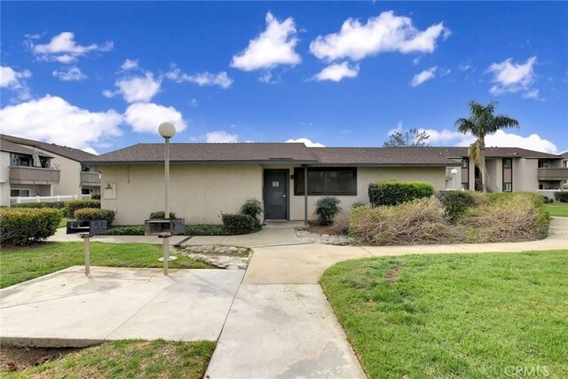 view of front of house with a front yard and stucco siding