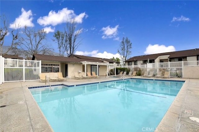 community pool featuring a patio area and fence