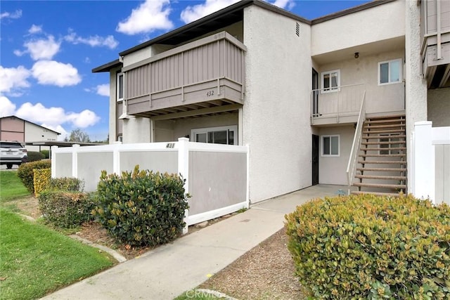 view of property with stairs and fence