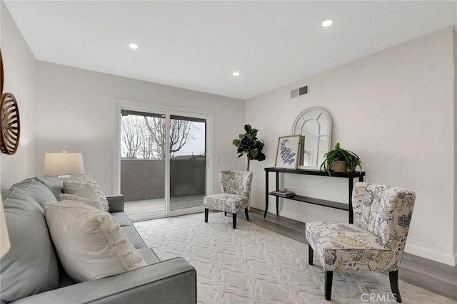 living area with recessed lighting, baseboards, visible vents, and light wood finished floors