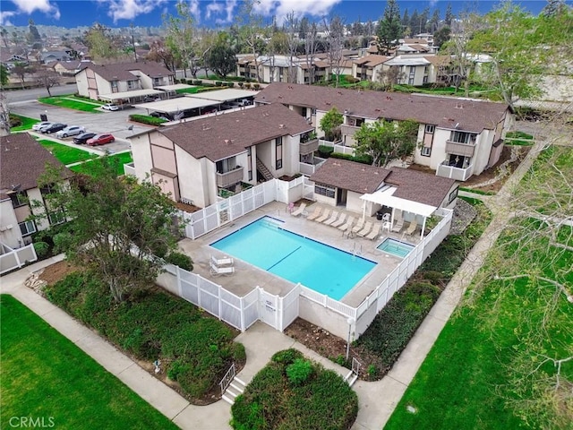 community pool with a residential view, a patio area, and a fenced backyard