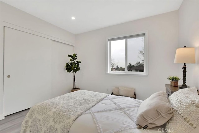 bedroom featuring a closet, light wood-type flooring, and recessed lighting