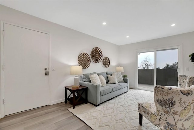 living area featuring baseboards, light wood finished floors, and recessed lighting