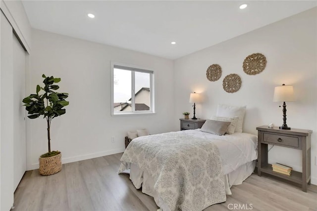 bedroom with recessed lighting, a closet, baseboards, and light wood finished floors