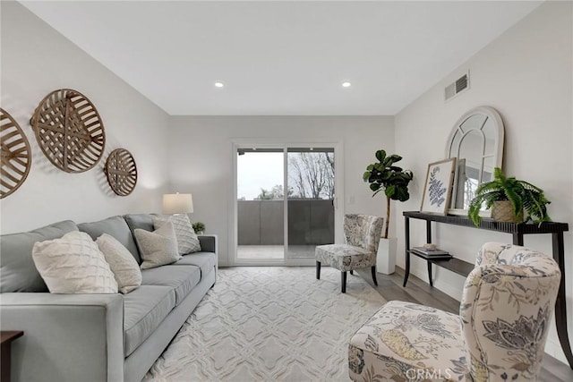 living room featuring recessed lighting, visible vents, baseboards, and wood finished floors