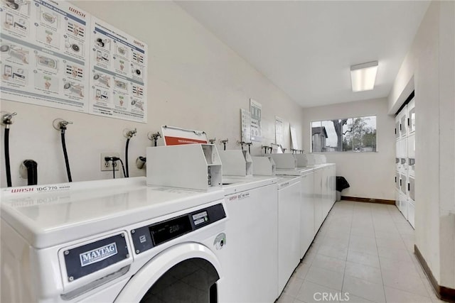 community laundry room featuring stacked washer and clothes dryer, washer and clothes dryer, baseboards, and light tile patterned floors