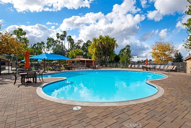 pool with a patio and fence