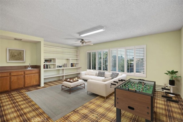 living room with a textured ceiling and a ceiling fan