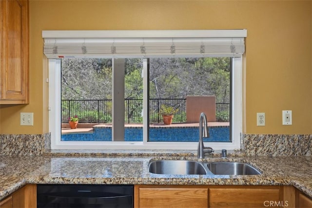 kitchen featuring a sink, stone countertops, brown cabinets, and black dishwasher