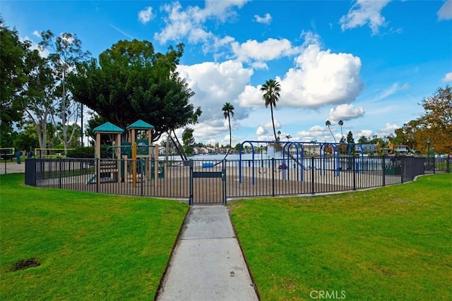 community play area with a lawn and fence