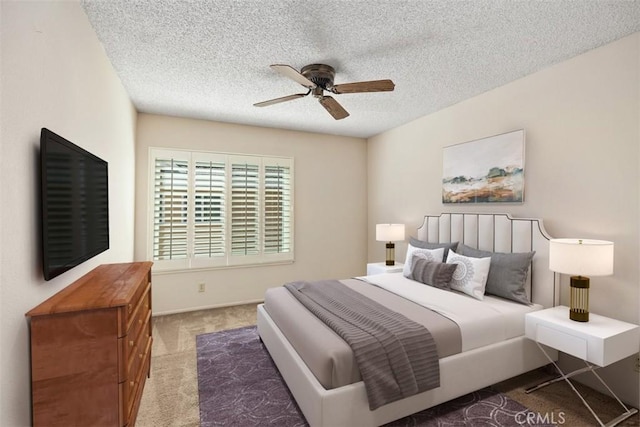 carpeted bedroom with a textured ceiling and a ceiling fan