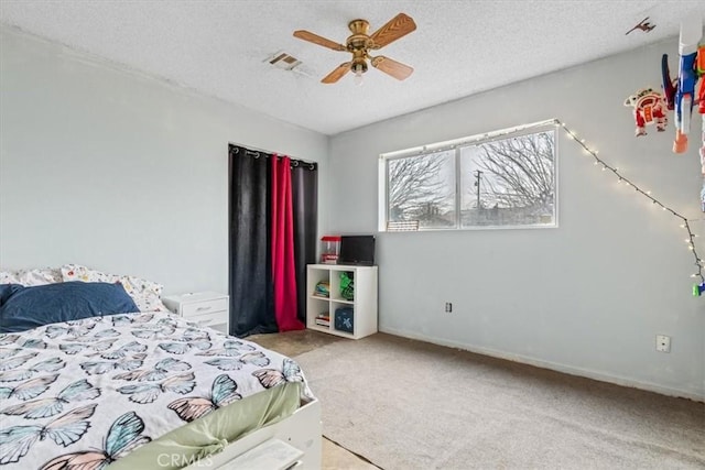 bedroom featuring a ceiling fan, carpet, visible vents, and a textured ceiling