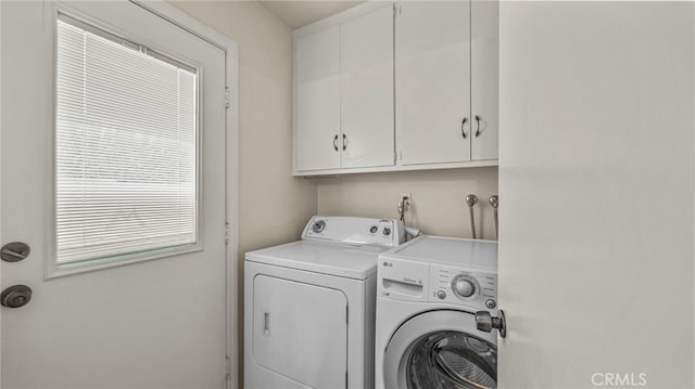 washroom with independent washer and dryer and cabinet space