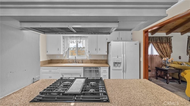 kitchen featuring a sink, white cabinets, light countertops, stainless steel dishwasher, and white fridge with ice dispenser