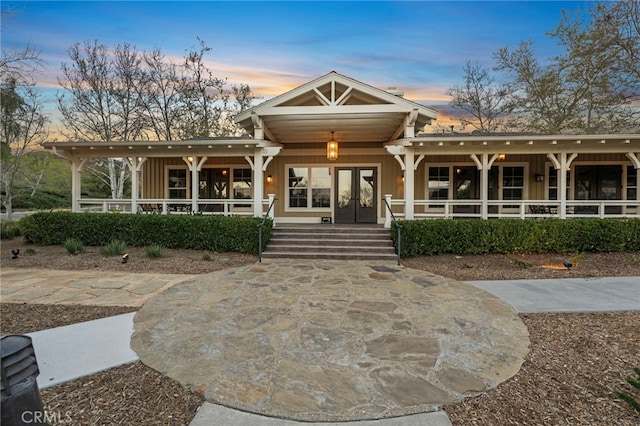 view of front of property featuring board and batten siding, french doors, and covered porch