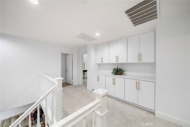 hall with light carpet, recessed lighting, visible vents, and an upstairs landing