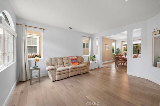 living area with light wood-type flooring and baseboards