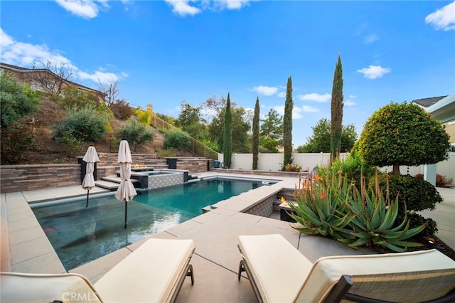 view of swimming pool featuring a pool with connected hot tub, a patio area, and a fenced backyard