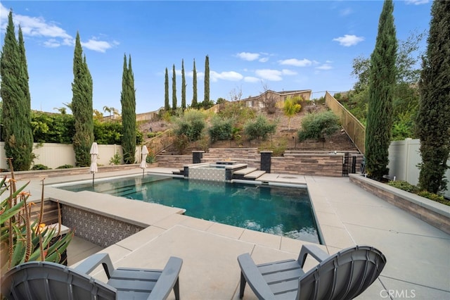 view of pool with a patio area, a fenced backyard, and a pool with connected hot tub