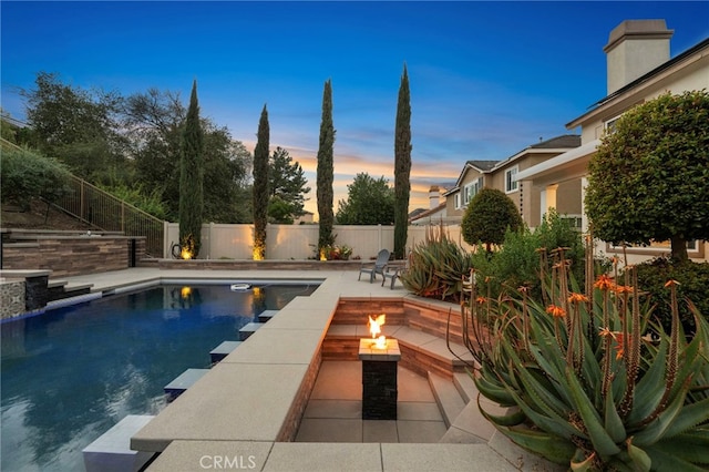 view of pool with an outdoor fire pit, a patio area, a fenced backyard, and a fenced in pool