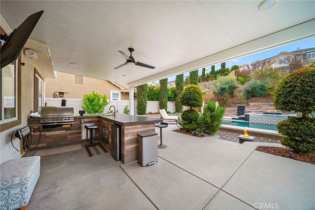 view of patio with a fenced backyard, outdoor wet bar, area for grilling, grilling area, and an outdoor pool