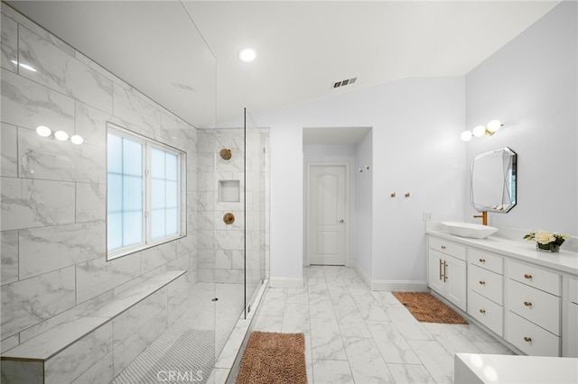 full bath featuring visible vents, baseboards, vaulted ceiling, marble finish floor, and a tile shower