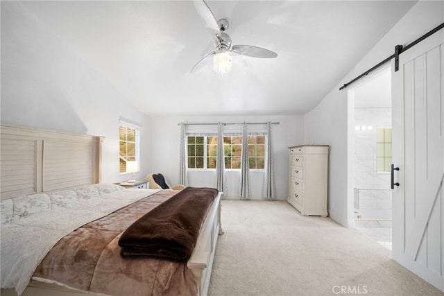 bedroom featuring lofted ceiling, a barn door, light carpet, connected bathroom, and ceiling fan