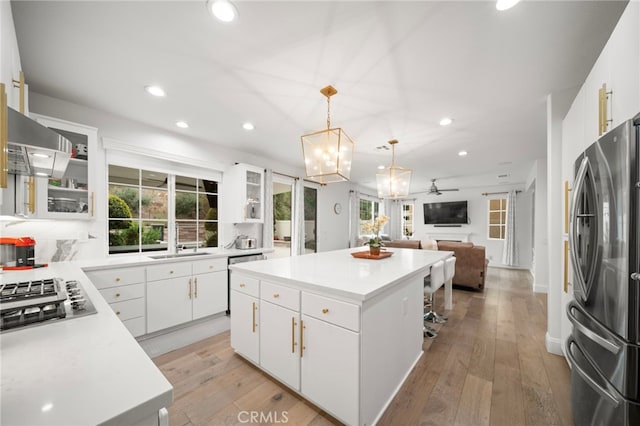 kitchen featuring a center island, light wood finished floors, stainless steel appliances, recessed lighting, and open floor plan