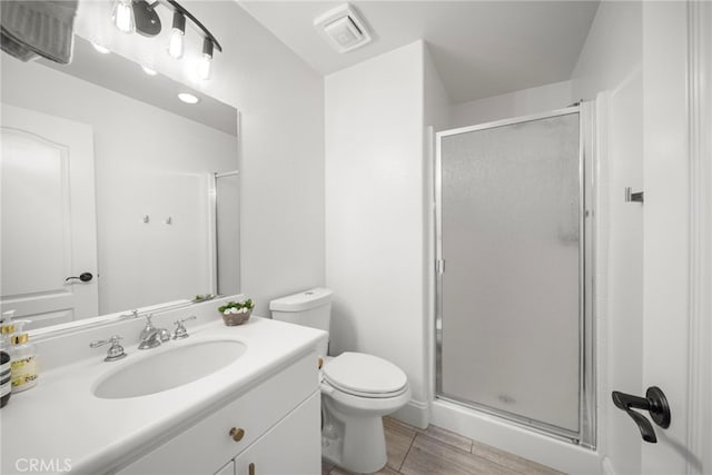 full bath featuring toilet, vanity, a shower stall, and visible vents