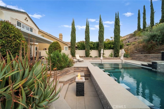 view of pool with a fire pit, a patio area, a fenced backyard, and a fenced in pool