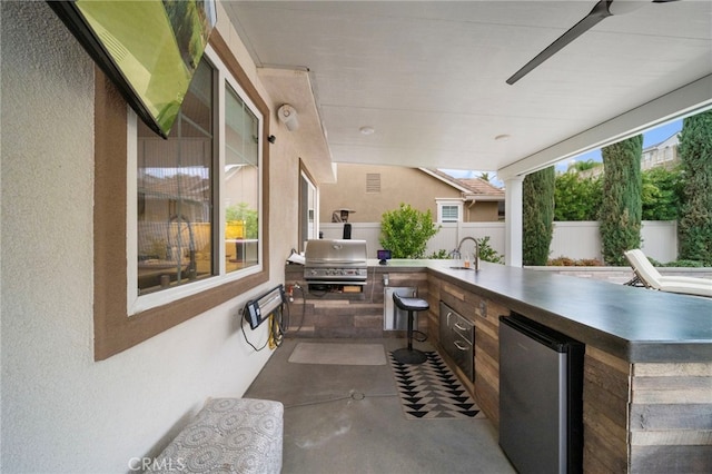 view of patio featuring a sink, fence, exterior kitchen, and area for grilling