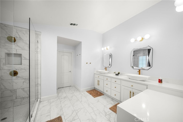 bathroom with marble finish floor, visible vents, a sink, tiled shower, and baseboards