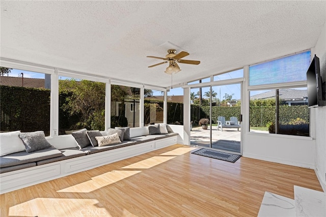 unfurnished sunroom featuring ceiling fan