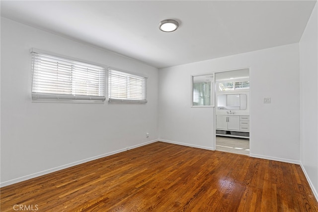 empty room featuring baseboards and wood finished floors