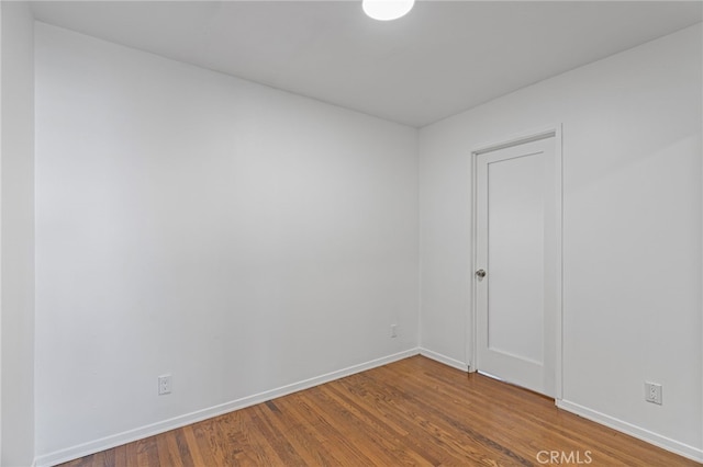 unfurnished room featuring baseboards and wood finished floors