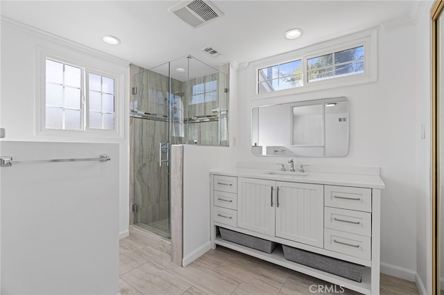 full bathroom featuring a stall shower, baseboards, visible vents, and vanity