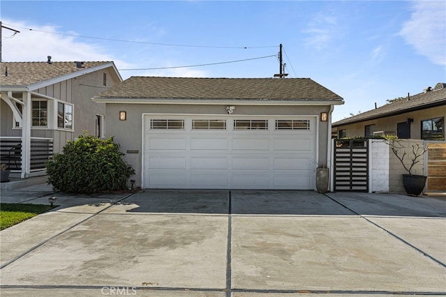 exterior space featuring a garage, roof with shingles, fence, and stucco siding