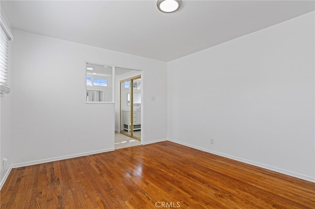 spare room with wood finished floors and baseboards