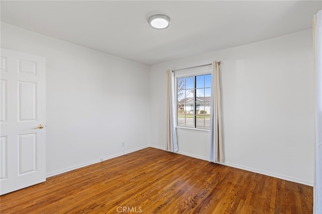 empty room with wood finished floors and baseboards