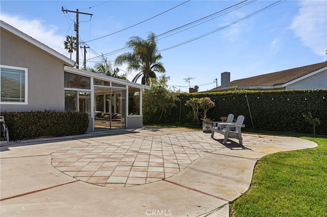 view of patio / terrace with a sunroom and fence