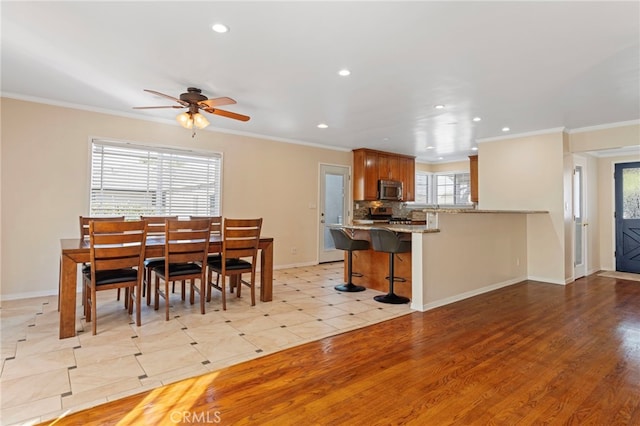 dining area with baseboards, ornamental molding, and recessed lighting