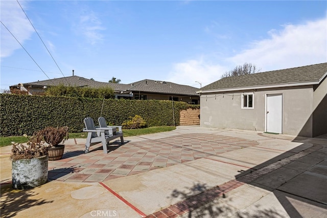 view of patio / terrace with fence and an outdoor structure